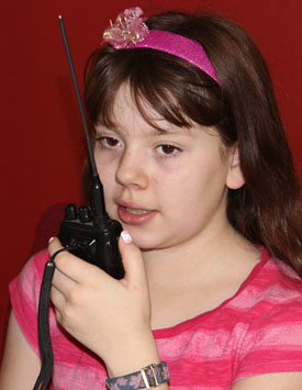 photo of young girl talking on hand held radio